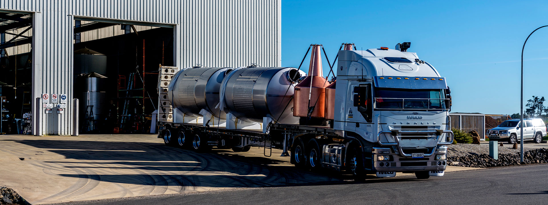 a white truck transporting big containers